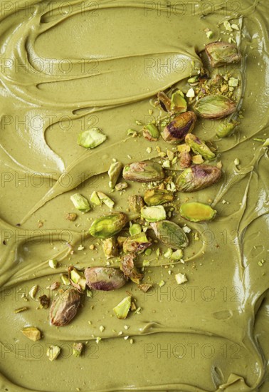 The texture of pistachio paste, with pistachios and crumbs, full frame, close-up