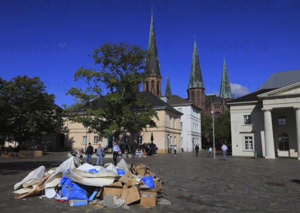 Schlossplatz with castle guard and St. Lambert's Church in the background, in front of it a pile of