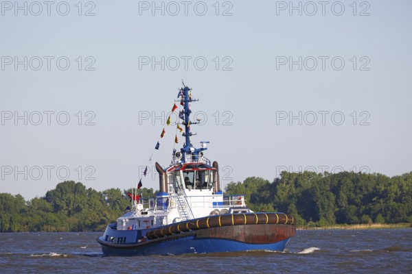 Decorated ship type Fairplay-91 tugboat leaves the port of Hamburg on the Elbe after Hamburg's port