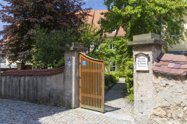 Entrance to the parish office of St. Nicolai through a gate through the wall, behind it historic