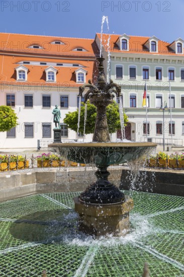 Sandstone market fountain on the medieval market square, in the background the monument to the