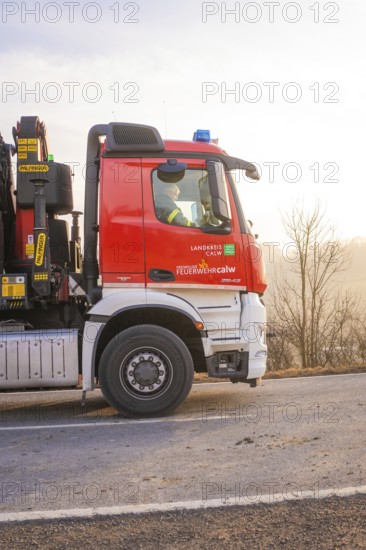 Red fire engine on a country road at sunset, fire brigade exercise on the Hermann Hesse Railway,