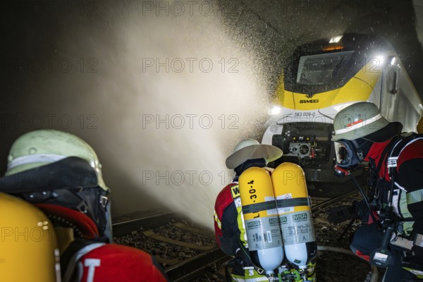 Firefighters spray a train in a tunnel with water. Respirators are used, fire department exercise