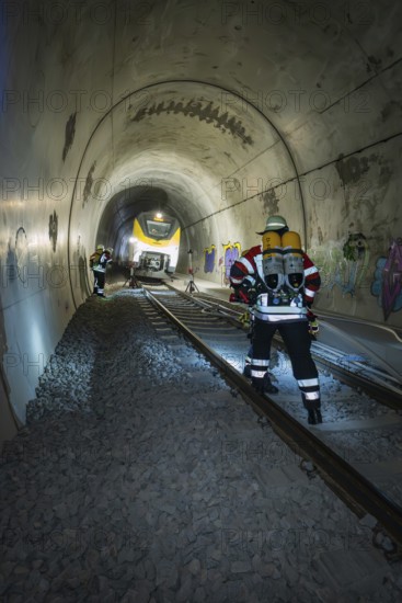 Firefighters with equipment work on rails in a tunnel, fire brigade exercise on the Hermann Hesse