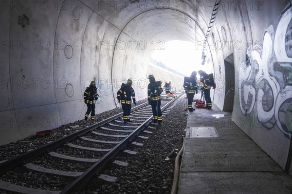 Firefighters working in a graffiti-covered tunnel, fire brigade exercise on the Hermann Hesse