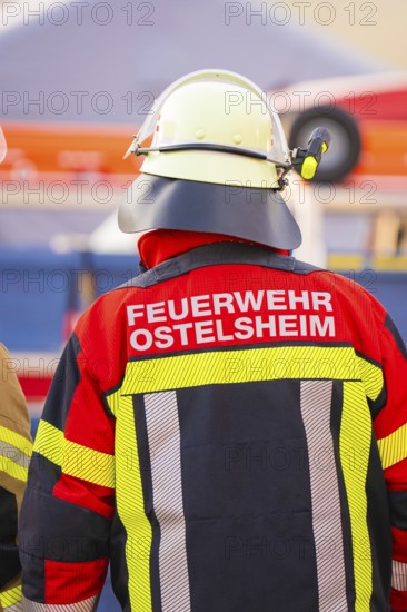 Firefighter from behind wearing colorful protective clothing and helmet, fire department exercise