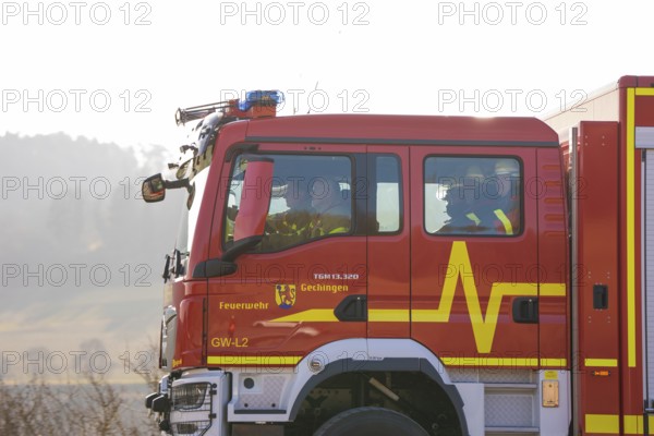 Closer look at a fire engine driving on a street with people inside, fire department exercise on
