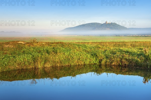 Landscape with lake in morning light, fog over the fields, the ruins of Gleichen Castle in the