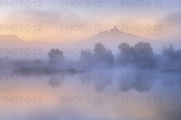 Landscape with lake at dawn at sunrise, fog rising, Wachsenburg fortress reflected in still water,