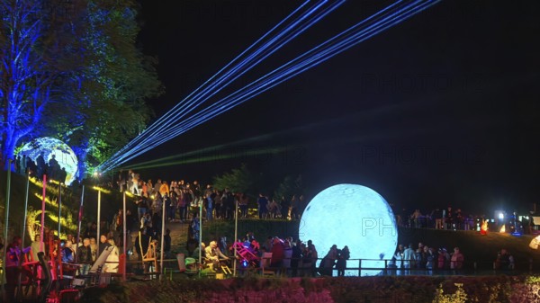 Festival atmosphere with lighting and a large blue ball on a hill, Kronach glows, Frankenwald