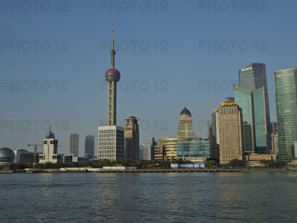 Panorama of a modern skyline of Huangpu Jiang with television tower and water in the foreground,