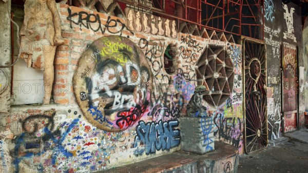 Different graffiti on a brick wall in an urban environment with a mix of cultures, Ljubljana,