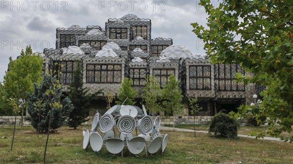 Architecturally distinctive building with domes and surrounding nature, National Library, Pristina,