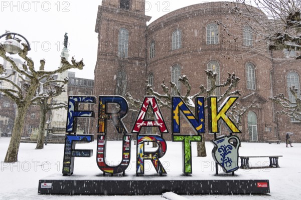 A passerby walks past St. Paul's Church in Frankfurt with an umbrella. Heavy snowfalls have caused