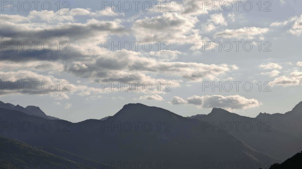 Mountain ranges in the background with clouds in the sky and a calm atmosphere, Peaks of the