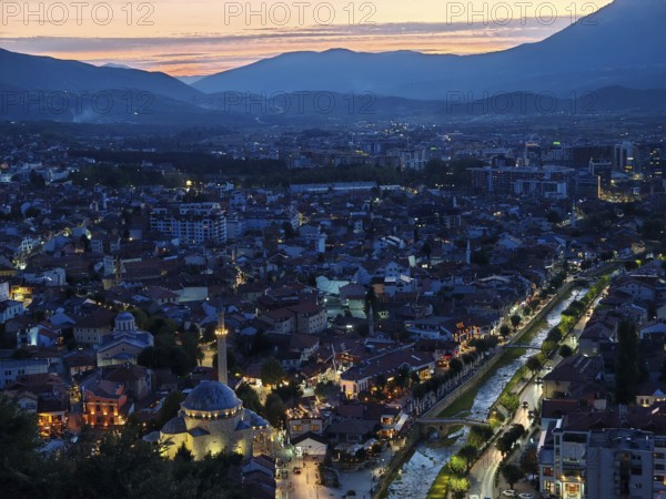 Night scene of an illuminated city with river and mountains in the background, Prizren, Kosovo