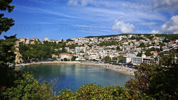 Picturesque coastal town on a bay under blue sky, surrounded by greenery, view of Ulcinj,