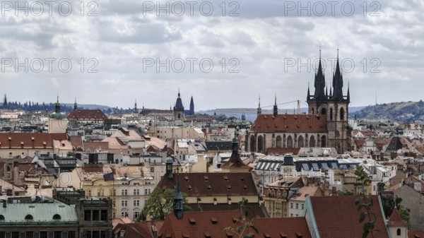 Historic city landscape with distinctive towers and roofs under a cloudy sky, Prague, Czech
