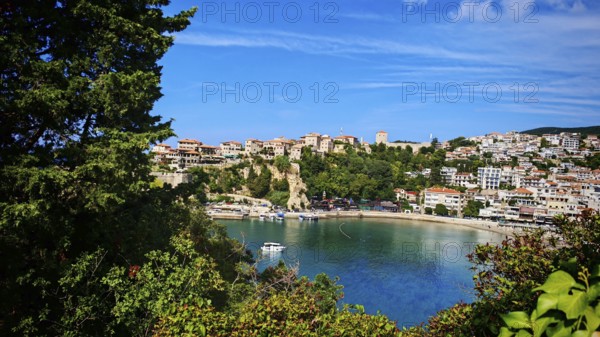 Panoramic view of a coastal town with boats and hills surrounded by clear skies, view of Ulcinj,