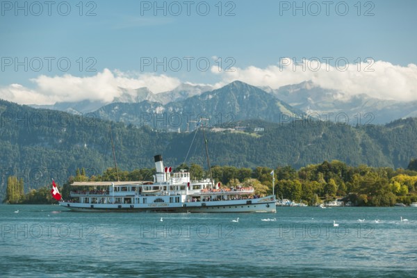 Lake Lucerne, Switzerland, Europe. A traditional boat on Lake Lucerne with the Swiss Alps in the