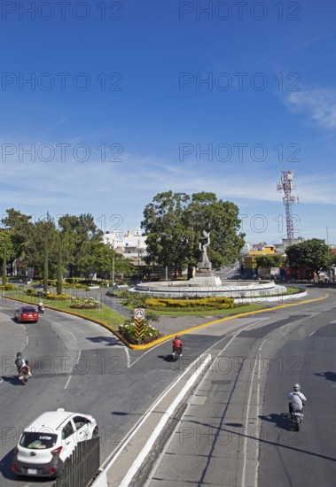 Street scene in zone 14 with the Peace Memorial or Monumento de la Paz in the back, Guatemala City,