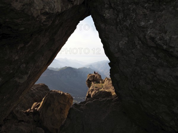 View through a rocky frame of a distant mountain landscape, Roque Nublo, Gran Canaria, Canary