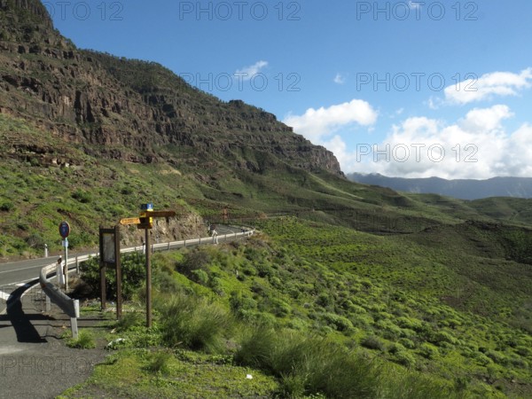 Scenic road through green mountains with clear skies, GC 200 near La Aldea de San Nicolas, Gran