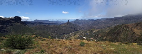 Wide mountain landscape with valley and cloudy sky in the distance. View from Cruz de Tejeda, Gran