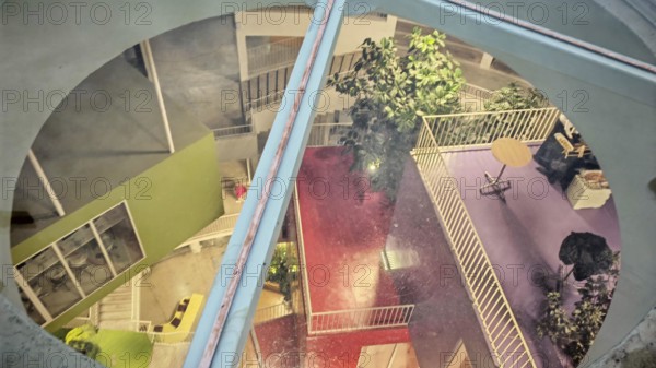 View of the colorful, modern courtyard of a building with plants and different levels, Tirana,