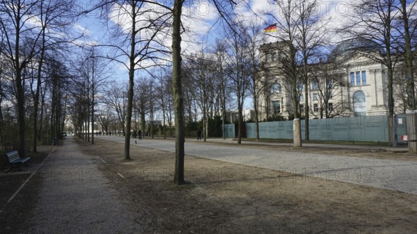 Promenade along the Reichstag with trees and sidewalk on a sunny day, deserted, without people,