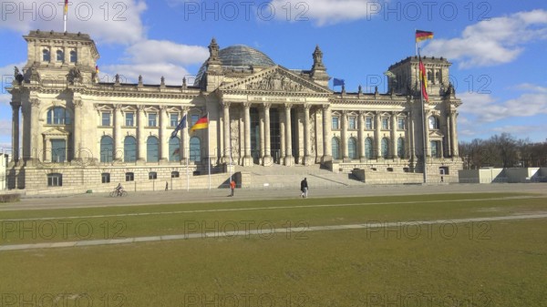 The Reichstag building in Berlin under a clear, blue sky, deserted, without people during corona,