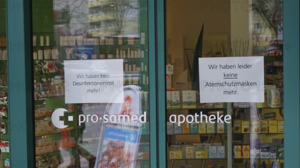 Pharmacy entrance with signs about missing disinfectants and protective masks, during corona,