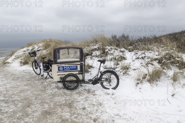Police bike in snowy dunes, Langeoog, Lower Saxony, Germany
