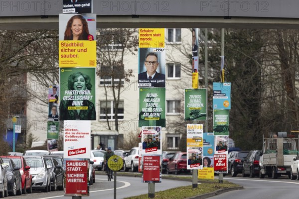 Numerous election posters for the 2026 local elections are hanging one behind the other on several