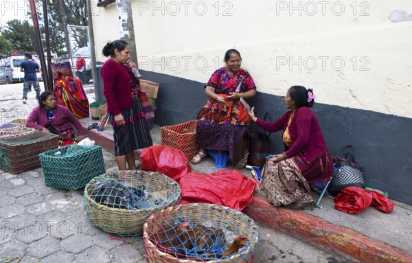 Mayan woman wearing traditional clothing sell chickens on the street in Chichicastenango,