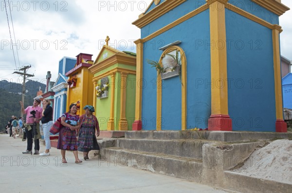 Mayan woman wearing traditional clothing at colorful graves at the cemetery in Chichicastenango,
