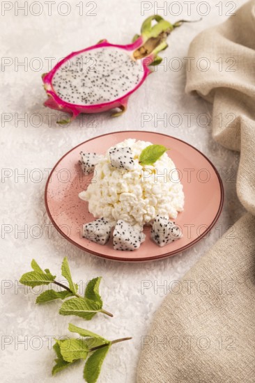 White ?ottage cheese, Curd, with Pithaya on gray concrete background and linen textile, side view,