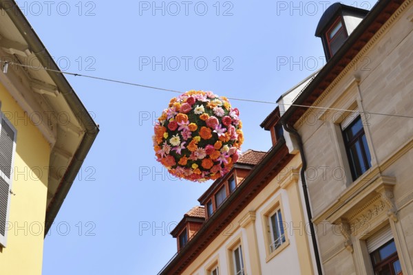 Ettlingen, Germany - August 13th 2025: Floral sphere of flowers hanging above street as summer