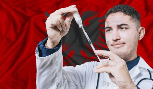Doctor holding syringe on Albania flag background. Medical professional holding syringe with