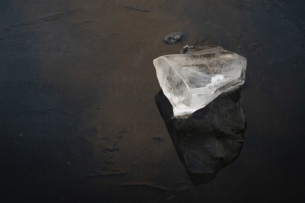 Piece of ice lies on the frozen surface of a lake, Finland
