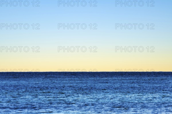 Minimalist illustration, horizon over the sea, clear evening sky, various shades of blue, calm