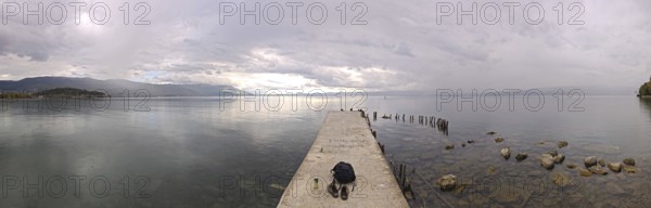Long footbridge leads into a vast lake surrounded by peaceful countryside, Lake Ohrid, North