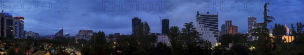Panoramic view of a skyline at dusk with skyscrapers and trees, Tirana, Albania