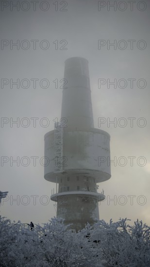 Mighty tower, surrounded by snow and fog, towering into the cloudy sky, Baköfele on the Schneeberg,