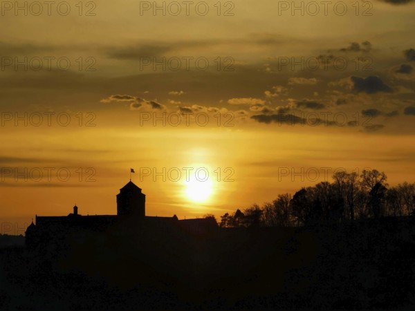 Silhouette of a castle in front of a glowing sunset