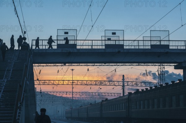 Siberia, Russia. People crossing a bridge at the train station near the Trans Siberian railway on