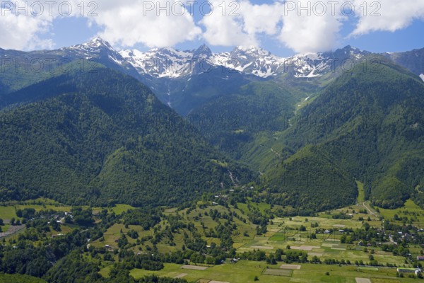 Extensive valley area with mountains in the background and small fields in the foreground,