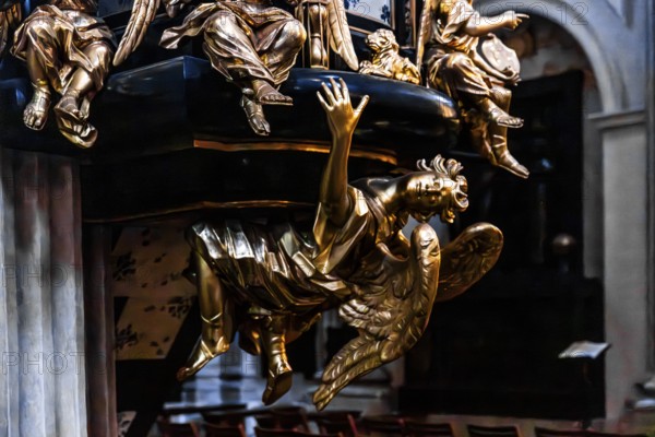 Richly decorated pulpit with intricate golden carvings, angel on the pulpit has symbolic meaning