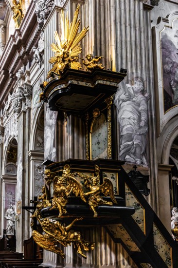 Richly decorated pulpit with intricate golden carvings, angel on the pulpit has symbolic meaning