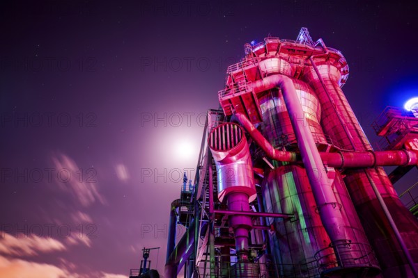Violet-lit industrial building under bright night sky, Landschaftspark Duisburg Nord, Duisburg,